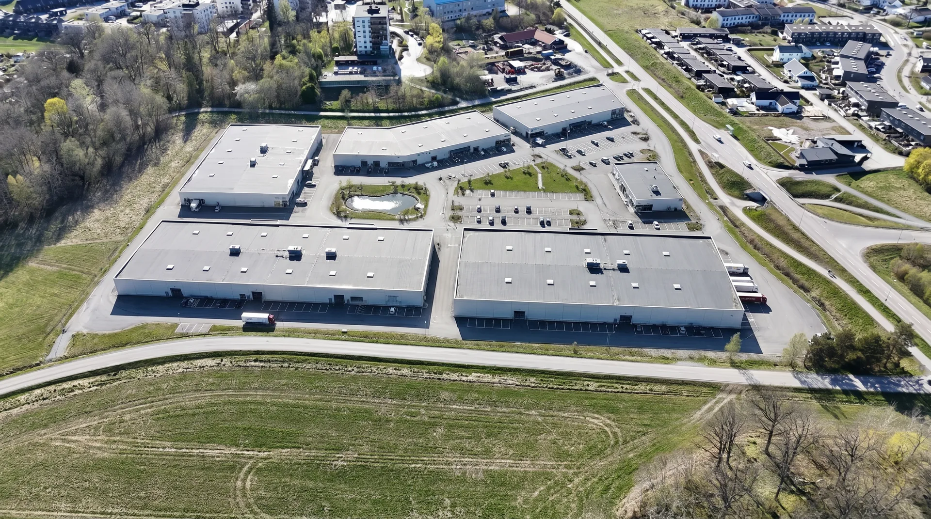 Illustration från öster av sex handelsbyggnader och parkeringar enligt det föreslagna planförslaget.
