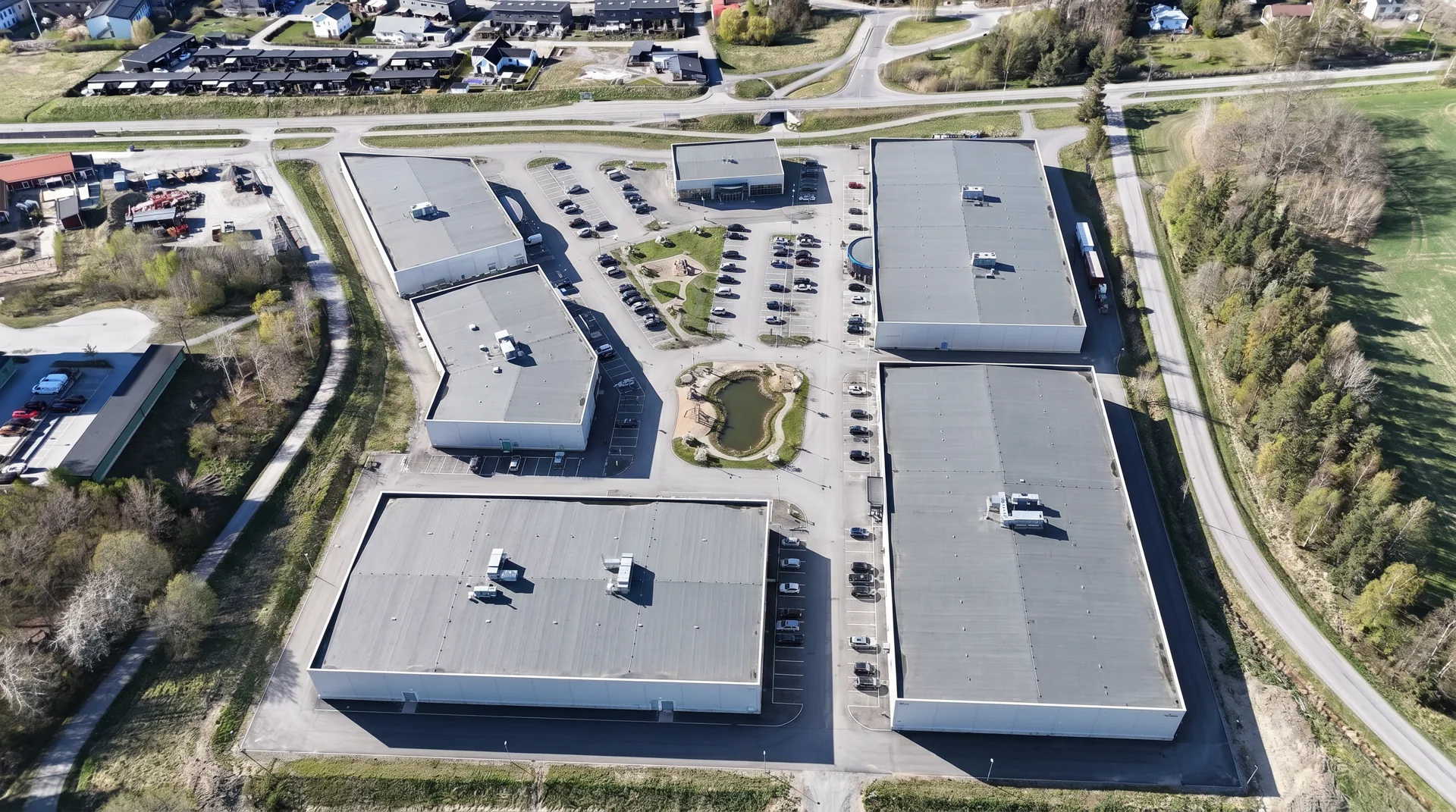 Bostadsområdet vid Körsbäret och Tulpansvampen i bakgrunden. Handelsbyggnaderna utgör en sluten fasadlinje mot landskapet.